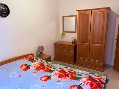 a bedroom with a bed with red flowers on it at Njaro del Mar Petrovac Bay in Petrovac na Moru