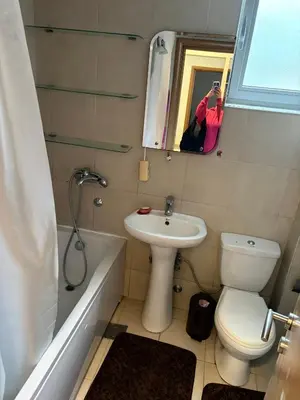 a person taking a picture of a bathroom with a toilet and sink at Njaro del Mar Petrovac Bay in Petrovac na Moru
