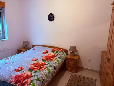 a bedroom with a bed with red flowers on it at Njaro del Mar Petrovac Bay in Petrovac na Moru