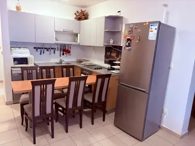 a kitchen with a refrigerator and a table with chairs at Njaro del Mar Petrovac Bay in Petrovac na Moru