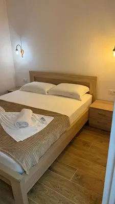 a bedroom with a bed with a white shirt on it at Morea Apartments in Ulcinj