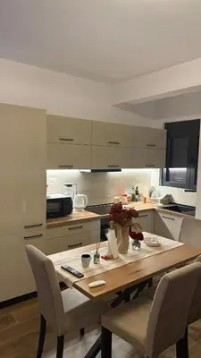a kitchen with a wooden table and chairs at Morea Apartments in Ulcinj