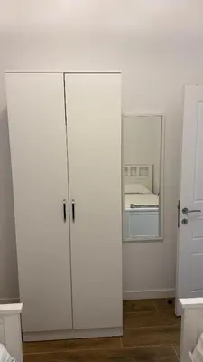 a bedroom with white cabinets and a mirror at Morea Apartments in Ulcinj