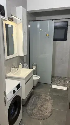 a bathroom with a sink and a washing machine at Morea Apartments in Ulcinj