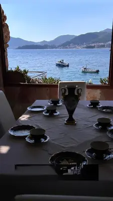 a table with a laptop on it with a view of the water at Villa Brodetto, Sveti Stefan in Pržno