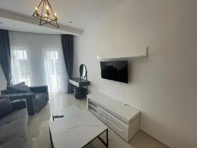 a living room with a couch and a tv on a wall at Apartments Amira in Ulcinj