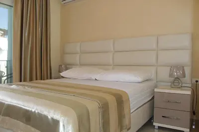 a bedroom with a large bed with a white headboard at Apartments Amira in Ulcinj