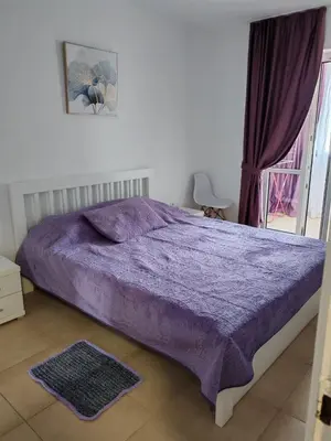 a bed with a purple comforter in a bedroom at Veli Vinogradi in Budva