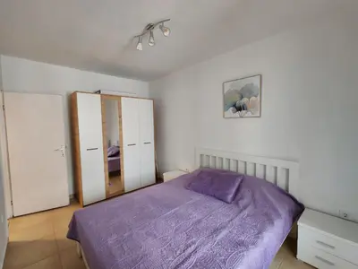 a bedroom with a purple bed and white walls at Veli Vinogradi in Budva