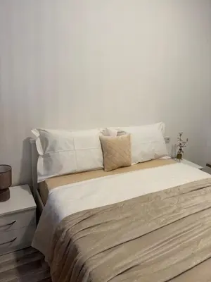 a bedroom with a large bed with white walls at Golden LUX in Bar