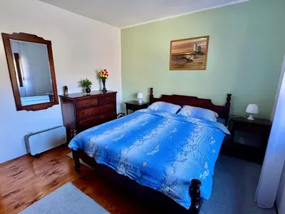 a bedroom with a blue bed and a mirror at Cindarella Apartment in Kotor