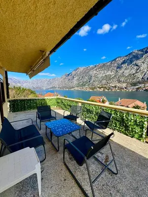 a patio with chairs and tables and a view of the water at Cindarella Apartment in Kotor