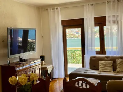 a living room with a couch and a tv and a window at Cindarella Apartment in Kotor