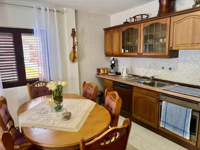 a kitchen with a wooden table and a table and chairs at Cindarella Apartment in Kotor