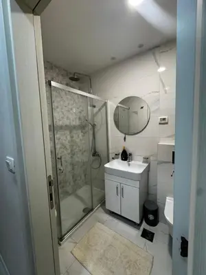 a bathroom with a shower and a sink and a mirror at Urban Stay in Podgorica
