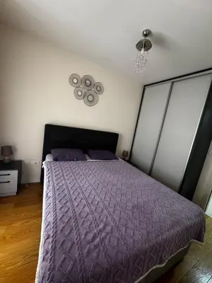 a bedroom with a purple bed and a fan at Urban Stay in Podgorica