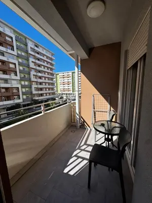 a balcony with a table and a chair on a building at Urban Stay in Podgorica