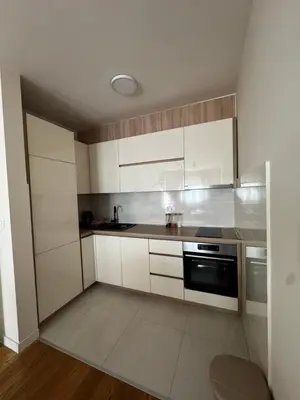 a kitchen with white cabinets and a sink and a stove at Urban Stay in Podgorica