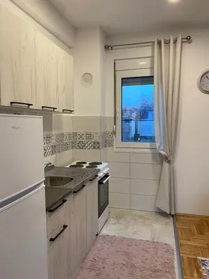 a kitchen with a refrigerator and a sink and a window at Jednosoban namješten stan - Cetinje in Cetinje