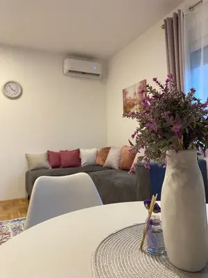 a living room with a vase with flowers on a table at Jednosoban namješten stan - Cetinje in Cetinje