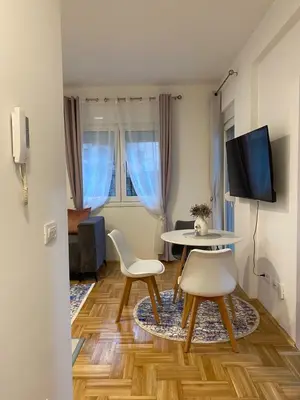 a living room with a table and chairs and a tv at Jednosoban namješten stan - Cetinje in Cetinje