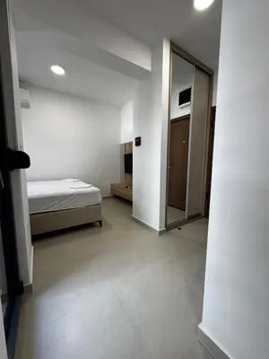 a white room with a bed and a mirror at Mayne Apartmant in Budva