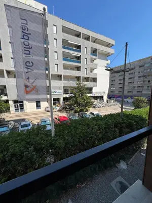 a large building with cars parked in a parking lot at Mayne Apartmant in Budva