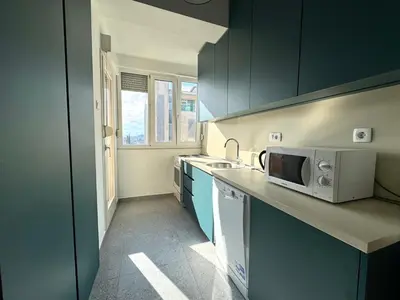 a kitchen with a sink and a microwave at The Government District Suite in Podgorica