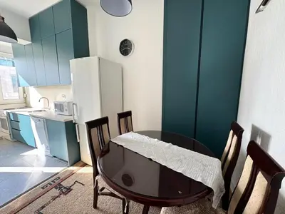 a kitchen with a table and chairs and a refrigerator at The Government District Suite in Podgorica