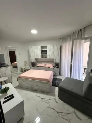 a large bedroom with a bed and a couch at ALEKS apartman in Rafailovici