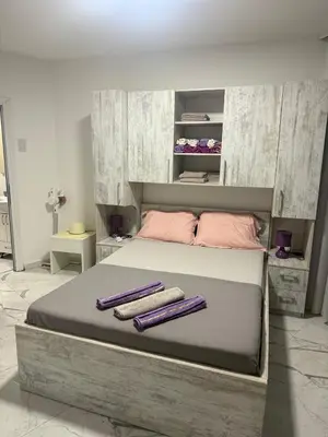 a bedroom with a large bed with two towels on it at ALEKS apartman in Rafailovici