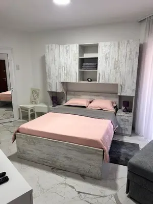 a bedroom with a large bed with pink sheets at ALEKS apartman in Rafailovici