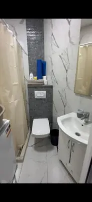 a bathroom with a white toilet and a sink at ALEKS apartman in Rafailovici