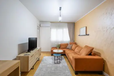 a living room with a couch and a television at The Point - Modern City Apartment in Kruševac