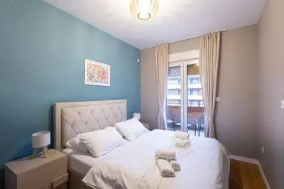 a blue bedroom with a bed with towels on it at The Point - Modern City Apartment in Kruševac