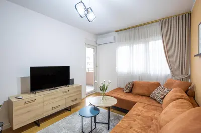 a living room with a couch and a flat screen tv at The Point - Modern City Apartment in Kruševac