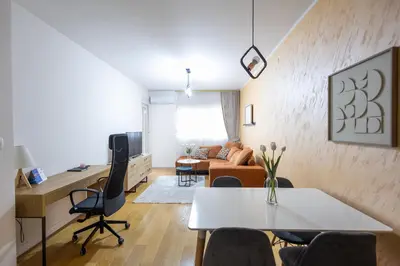 a living room with a table and a desk at The Point - Modern City Apartment in Kruševac