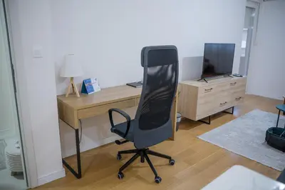 an office with a desk and a chair and a television at The Point - Modern City Apartment in Kruševac