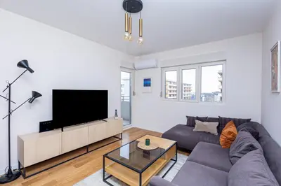 a living room with a couch and a flat screen tv at Urban Stay - Central Point Apartment in Kruševac