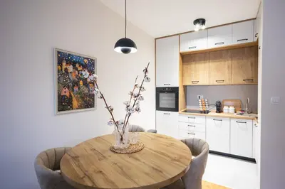 a kitchen with a round wooden table and chairs at Urban Stay - Central Point Apartment in Kruševac