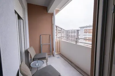 a balcony with two chairs and a table on a building at Urban Stay - Central Point Apartment in Kruševac