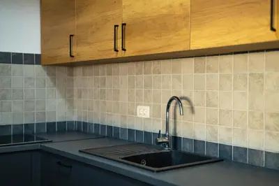 a kitchen counter with a sink and wooden cabinets at Apartment sea view Asija in Bar