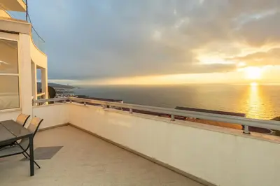 a balcony with a view of the ocean at sunset at Apartment sea view Asija in Bar