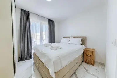 a bedroom with a large bed and a large window at Malik Bay RESIDENTS in Bar