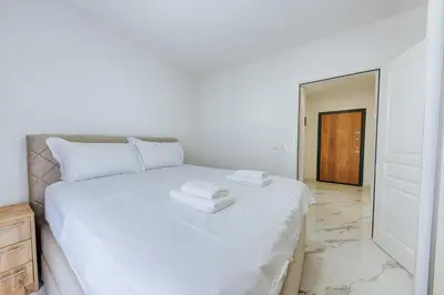 a bedroom with a white bed with two towels on it at Malik Bay RESIDENTS in Bar