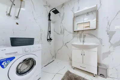 a white laundry room with a washing machine and a sink at Malik Bay RESIDENTS in Bar