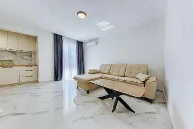 a living room with a couch and a table at Malik Bay RESIDENTS in Bar