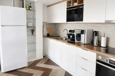 a kitchen with white cabinets and a wooden counter top at Blue Vista in Petrovac na Moru