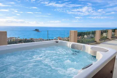 a hot tub on a balcony with a view of the ocean at Blue Vista in Petrovac na Moru