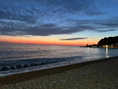a sunset on the beach with the shoreline at Blue Vista in Petrovac na Moru